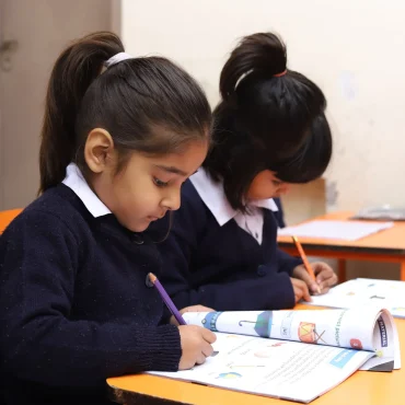 Focused students writing in workbooks during a lesson.